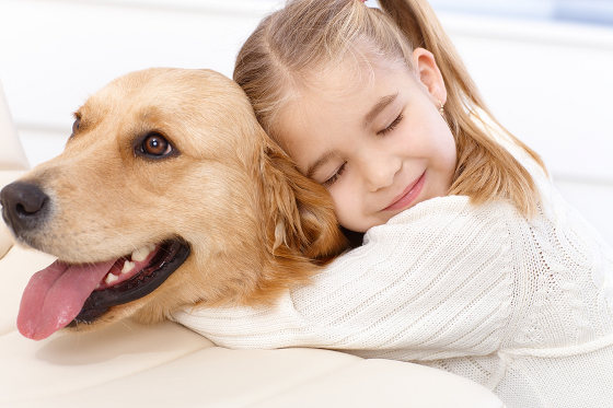 girl hugging golden retriever